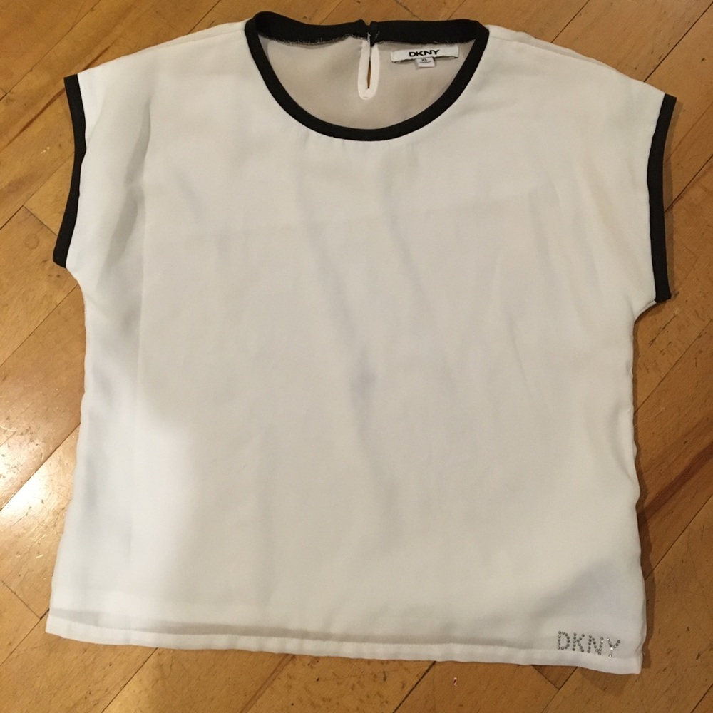 White blouse with black trim. DKNY rhinestone logo
